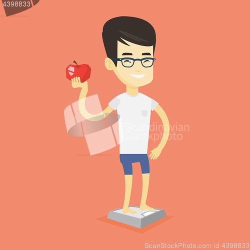 Image of Man standing on scale and holding apple in hand.