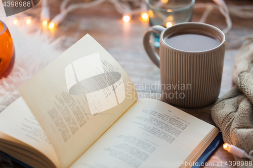 Image of book and cup of coffee or hot chocolate on table