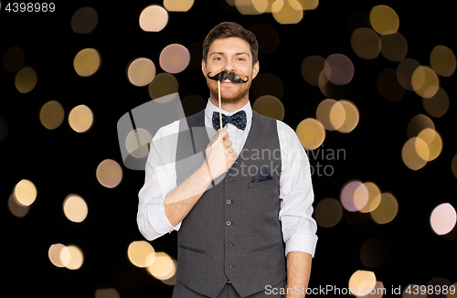 Image of happy young man with fake mustache at party