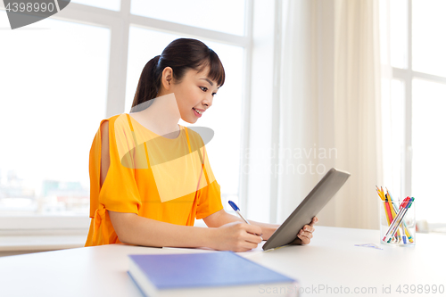 Image of asian student girl with tablet pc learning at home