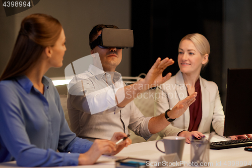 Image of business team with computer working late at office