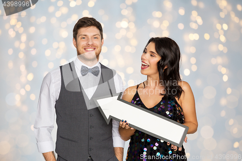 Image of happy couple with big arrow at party