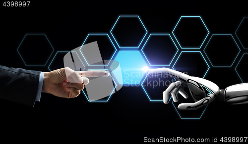 Image of robot and human hand touching network hologram