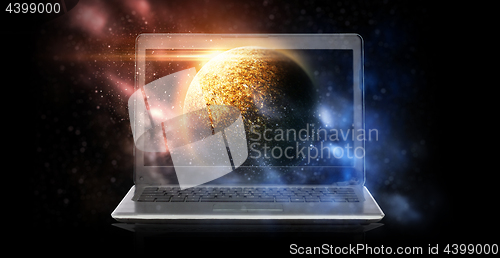 Image of laptop with virtual planet and space hologram