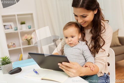 Image of mother student with baby and tablet pc at home