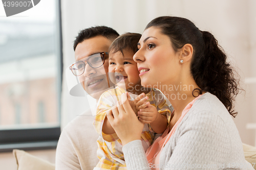 Image of happy family with baby daughter at home