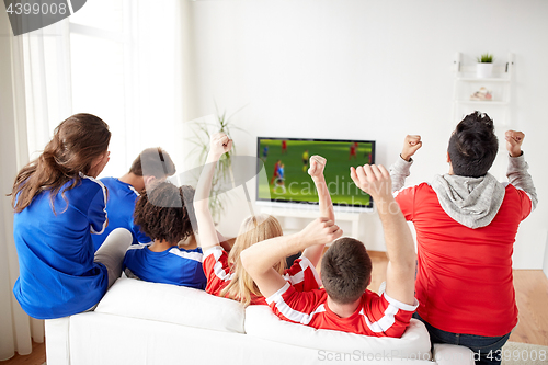 Image of friends or soccer fans watching game on tv at home