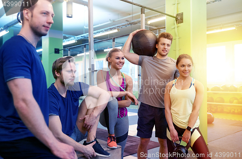 Image of group of friends with sports equipment in gym