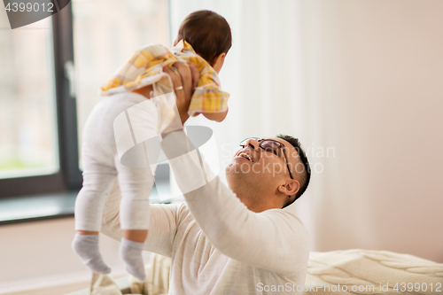 Image of happy father holding little baby daugter at home