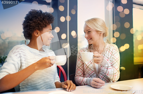 Image of happy young women drinking tea or coffee at cafe