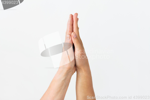 Image of close up of senior and young woman touching hands