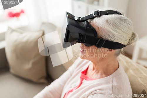 Image of old woman in virtual reality headset or 3d glasses