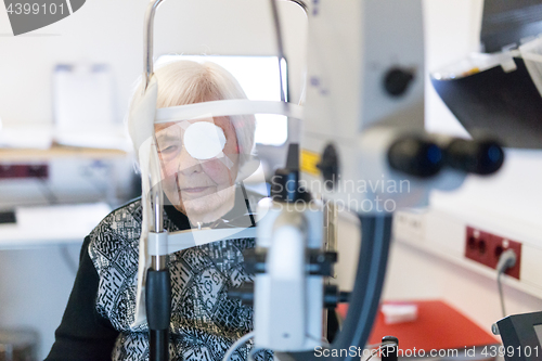 Image of Senior woman wearing eye pathc after laser surgery procedure at ophthalmology clinic.