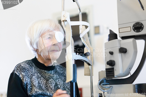 Image of Senior woman wearing eye pathc after laser surgery procedure at ophthalmology clinic.