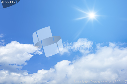 Image of bright blue sky with sun and clouds background