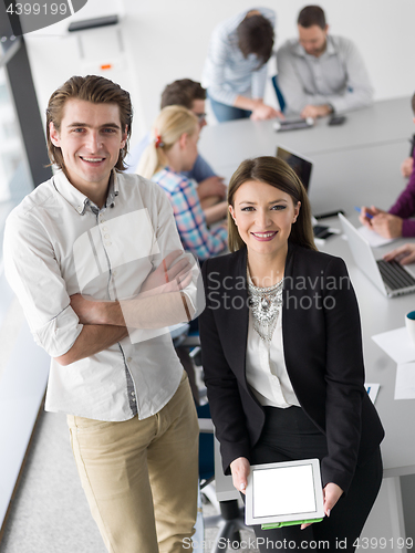 Image of Two Business People Working With Tablet in office