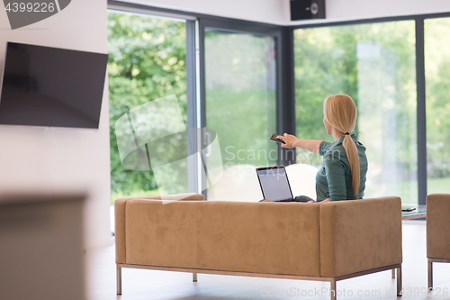 Image of Young woman using laptop at home