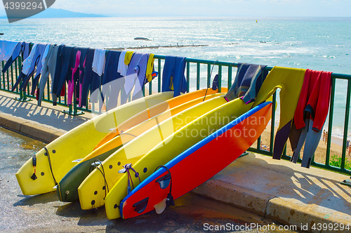 Image of Surfboards and wetsuits at beach