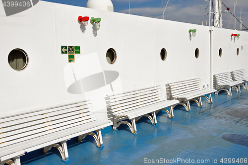 Image of benches and portholes on ship deck