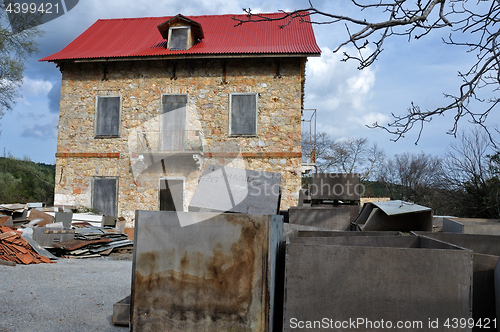 Image of derelict stone house and pile of box crates