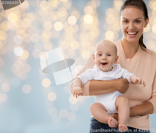 Image of happy mother with little baby boy over lights