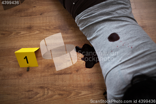 Image of dead woman body in blood on floor at crime scene