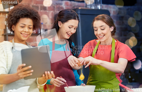 Image of happy women with tablet pc in kitchen