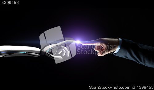 Image of robot and human hand connecting fingers