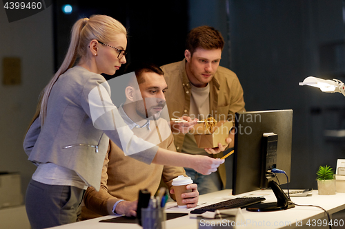 Image of business team with computer working late at office