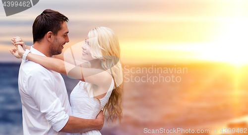 Image of happy couple hugging over sea background