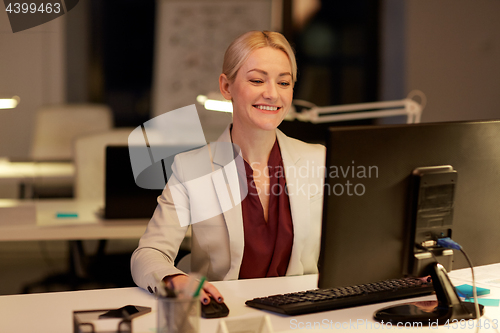 Image of businesswoman at computer working at night office