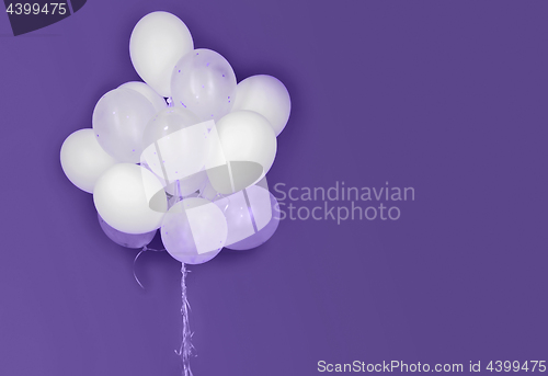 Image of white helium balloons on ultra violet background