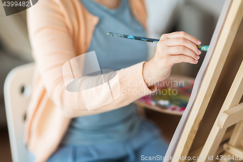 Image of artist with brush painting at art studio