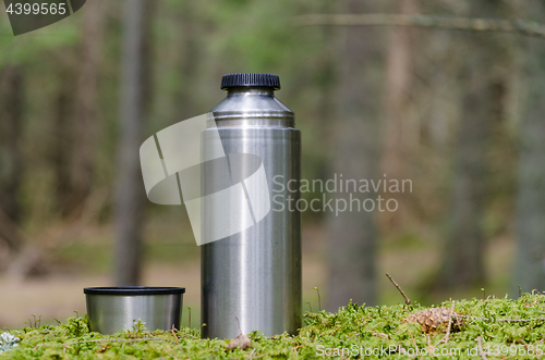 Image of Thermos and cup on a mossy ground