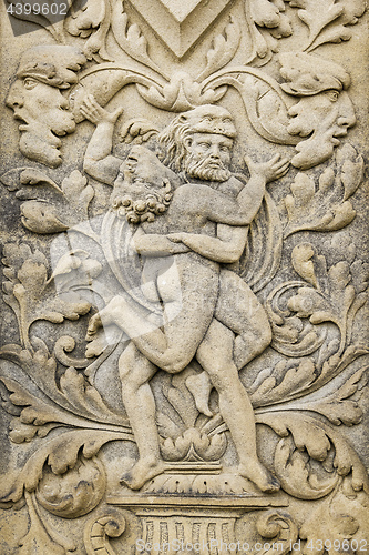 Image of a sand stone relief of two men fighting