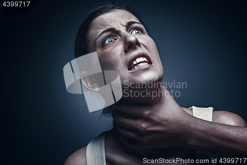 Image of Home violence - young woman is choked by man\'s hand