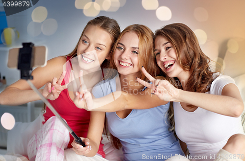 Image of teen girls with smartphone taking selfie at home