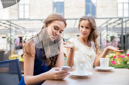 Image of young women with smartphone and coffee at cafe