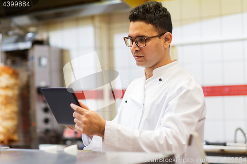 Image of chef cook with tablet pc at restaurant kitchen