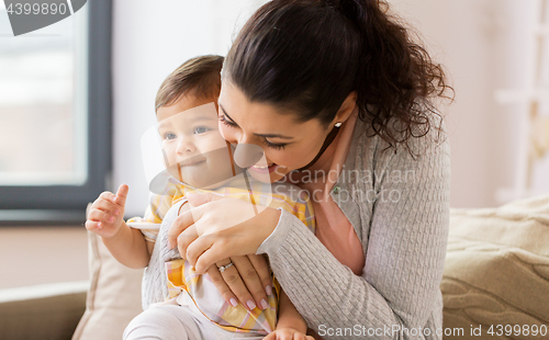 Image of happy smiling mother with baby daughter at home