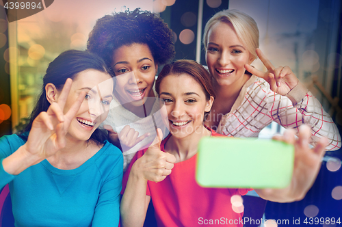 Image of happy young women taking selfie with smartphone