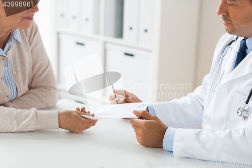 Image of woman and doctor with prescription at clinic