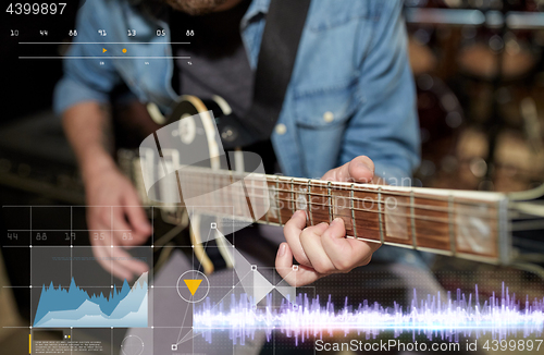 Image of close up of man playing guitar at studio rehearsal