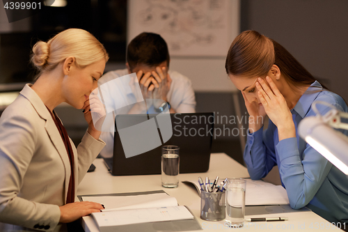 Image of business team with laptop working late at office