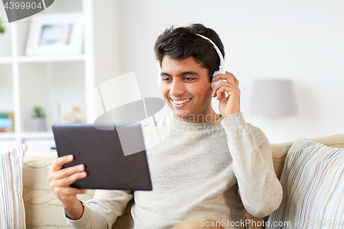 Image of man in phones with tablet pc listening to music