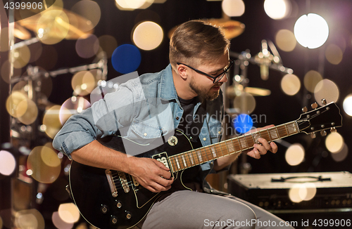 Image of man playing guitar at studio rehearsal