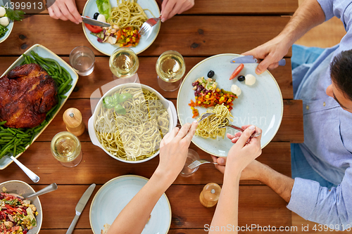 Image of people at table with food eating pasta for dinner