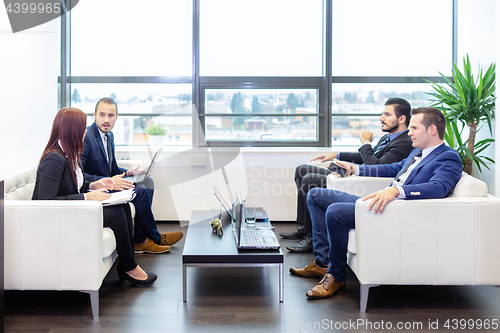 Image of Business people sitting at working meeting in modern corporate office.