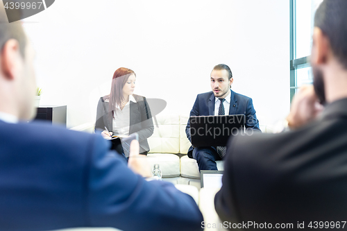 Image of Business people sitting at working meeting in modern corporate office.