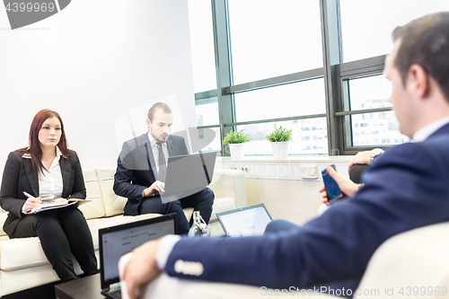 Image of Business people sitting at working meeting in modern corporate office.